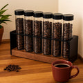 Organizador de tubos para granos de café sobre una mesa de madera