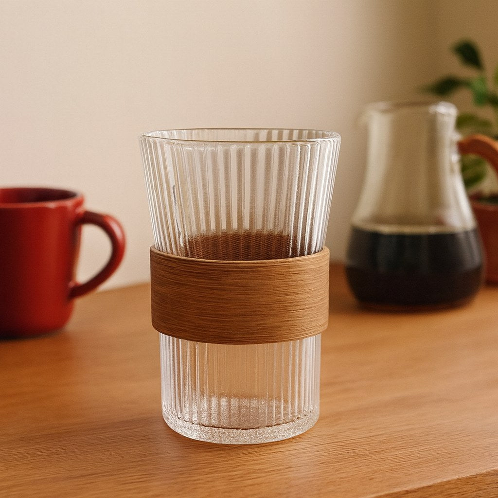 Vaso alto de vidrio con banda sobre una mesa de madera